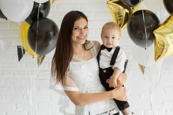 madre-e-hijo-celebrando-primer-cumpleanos-juntos-riendo-sonriendo-globos_199620-1446